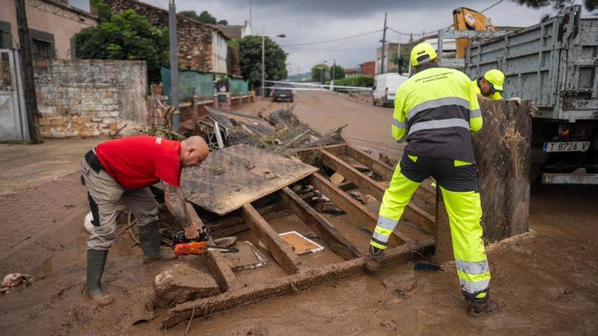 Vecinos y bomberos colaboran en la limpieza de enseres personales y calles de Santa Bàrbara (Montsià) tras el paso de la dana Alice.