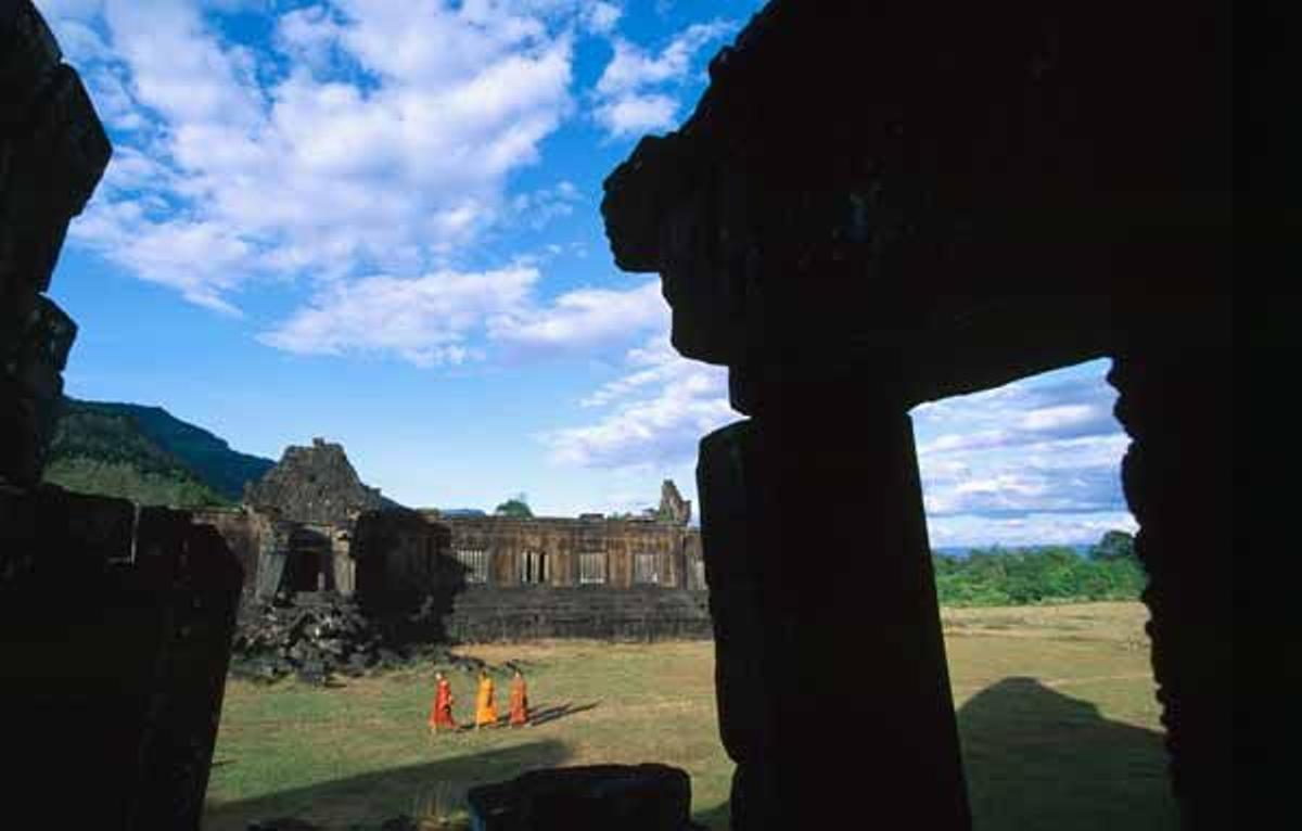 Monjes budistas pasean por las ruinas de Wat Phu.