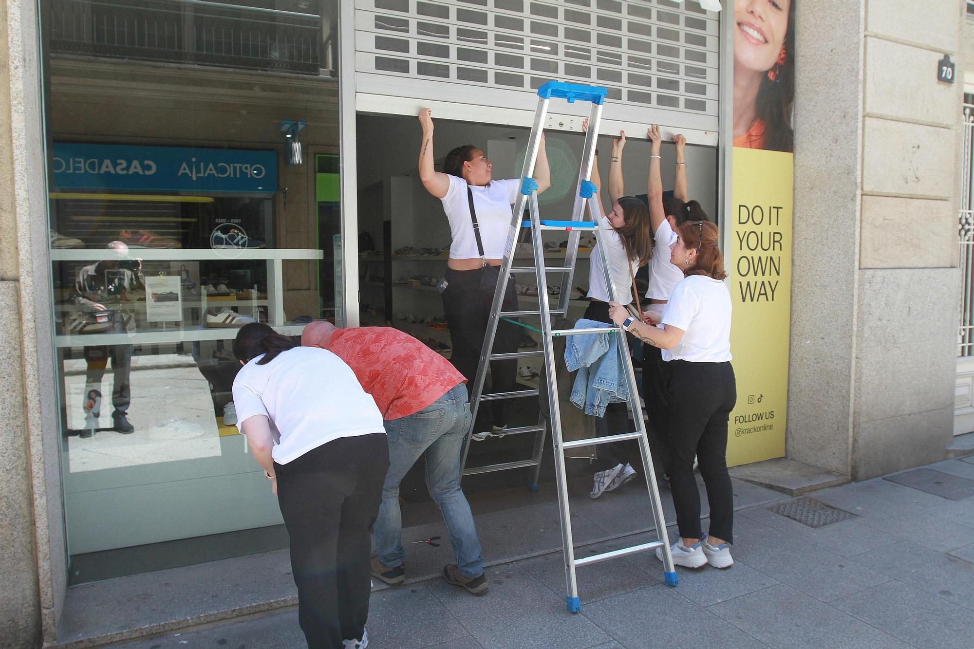 Comerciantes bajan la verja eléctica de un local en Ourense