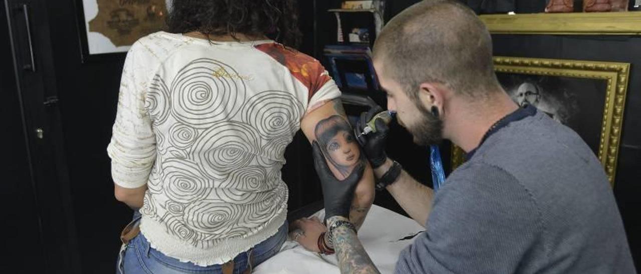 Una de las usuarias haciéndose un tatuaje en el antebrazo donde antes tenía una cicatriz .