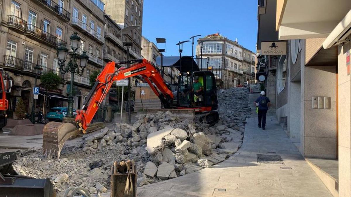 Una máquina levanta el firme de la calle A Laxe, al lado de Carral.