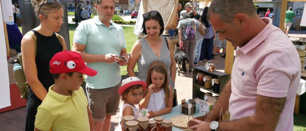 José María Bello reparte miel en uno de los puestos de la feria.   | // S.Á.