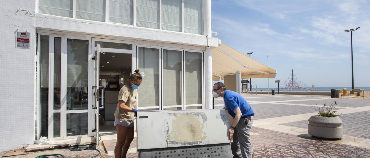 Unos trabajadores preparan un local del paseo marítimo para su reapertura, en una imagen de archivo.