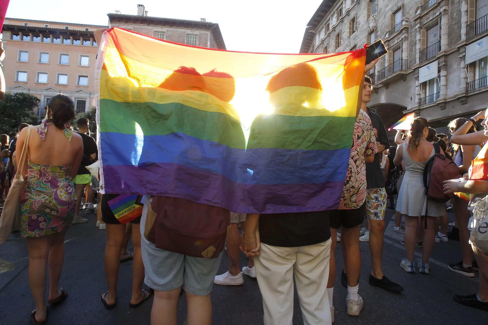 Dos personas con una bandera durante una manifestación por el Orgullo LGTBI.