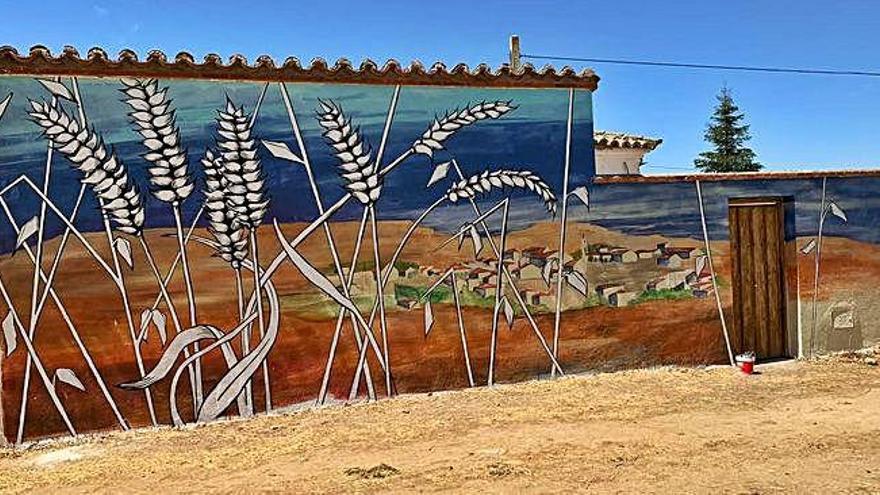 Sobre estas líneas, el mural en memoria de las víctimas de la represión en Torres del Carrizal; a la izquierda la muralista Verónica Werckmeister durante la elaboración del trabajo.