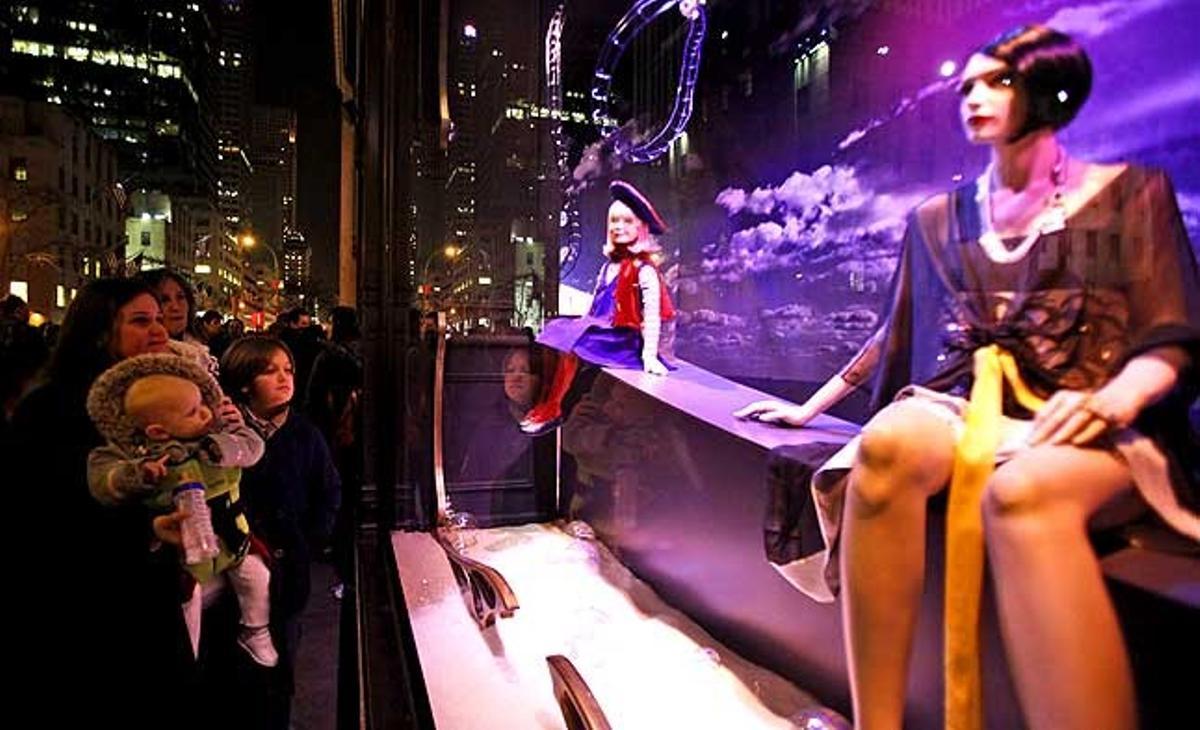 Un grup de persones miren l’aparador de la botiga Macy’s a Nova York (Estats Units).