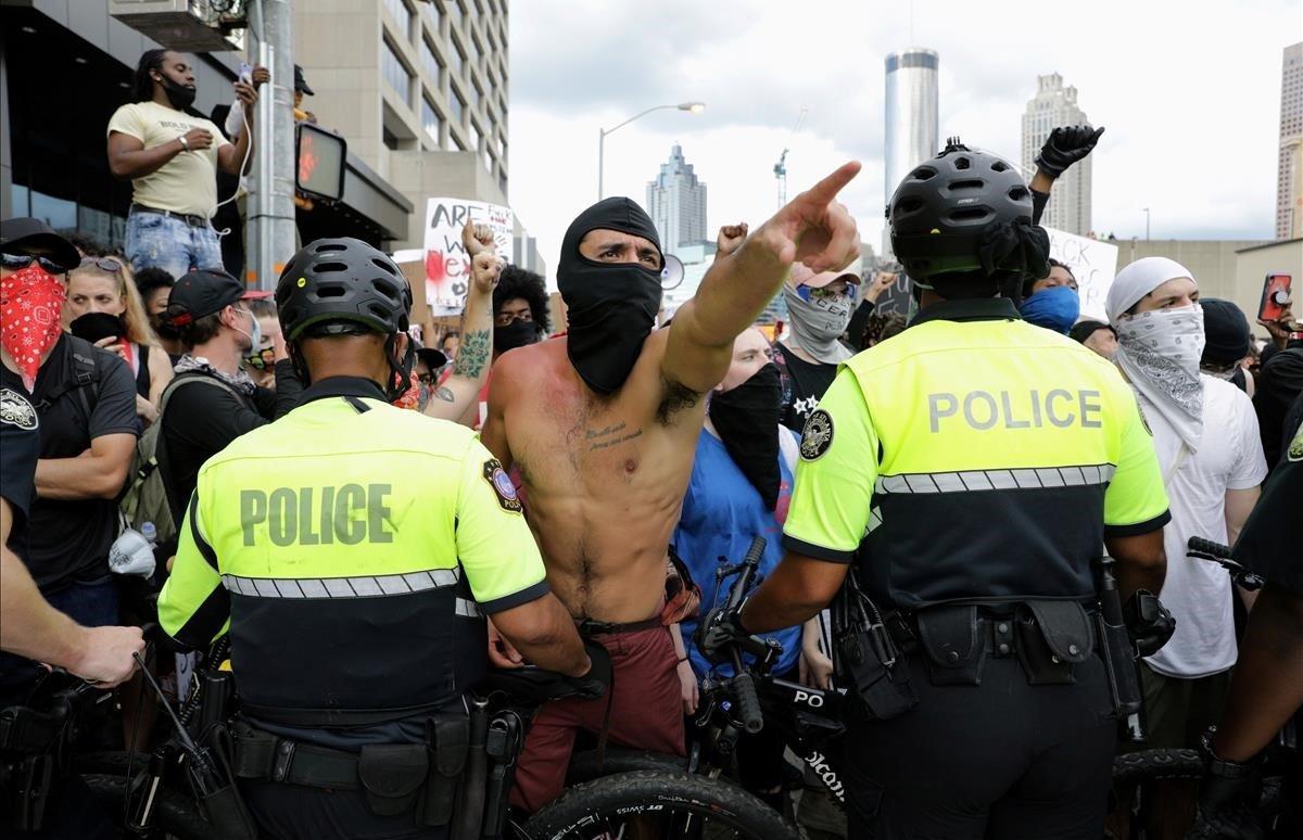 La policía y los manifestantes se enfrentan frente a la CNN en Atlanta.