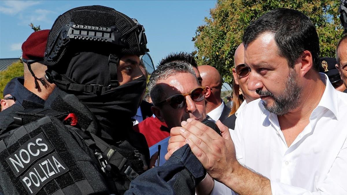 Salvini da la mano a un miembro de la policia especial italiana en un acto commemorativo