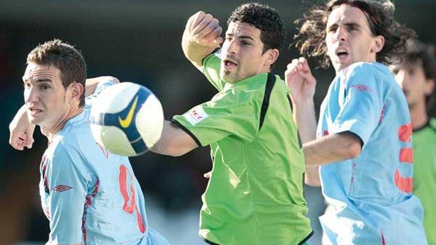 David Rodríguez y Jordi siguen la pelota con la mirada junto a un jugador del Córdoba en una jugada a balón parado.