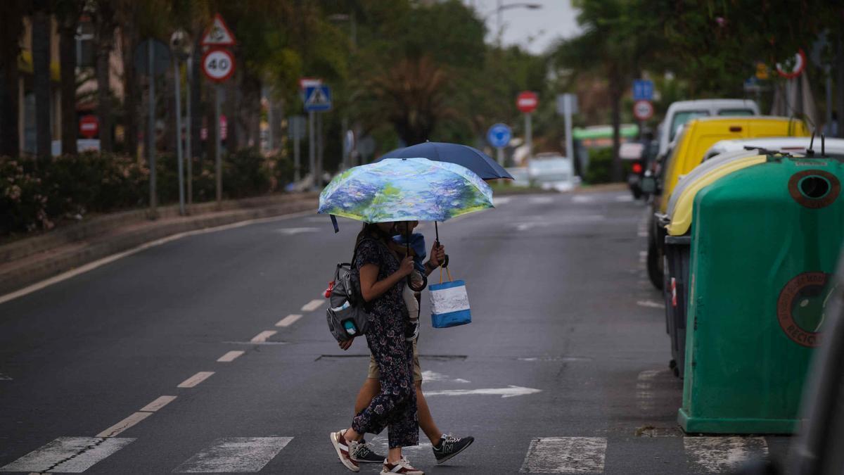 Dos personas se protegen de la lluvia en Santa Cruz de Tenerife.