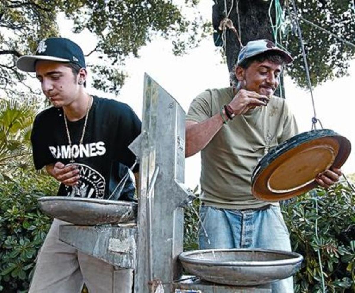 Dos acampados junto a una fuente de la plaza de Catalunya.