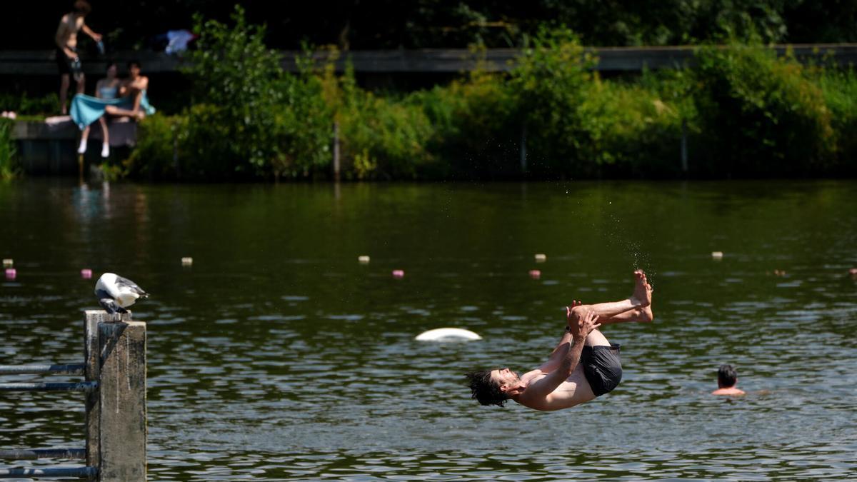 Londinenses se refrescan  en una piscina al aire libre en Hampstead Heath, durante la ola de calor de junio.