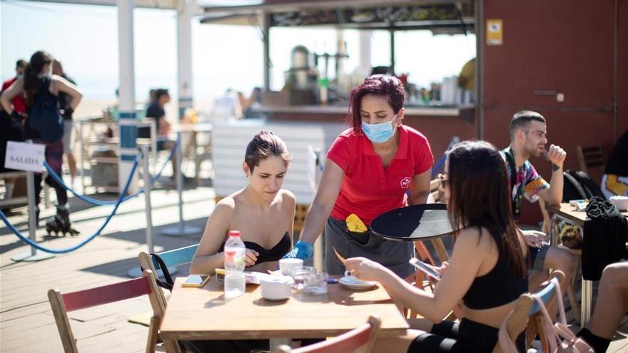 Dos mujeres son atendidas en un chiringuito de una playa de Barcelona.