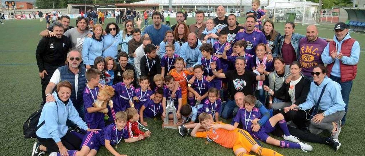 Jugadores del Celta y sus familiares posan sobre el césped del Manuel Jiménez con el trofeo de campeón. // Noé Parga