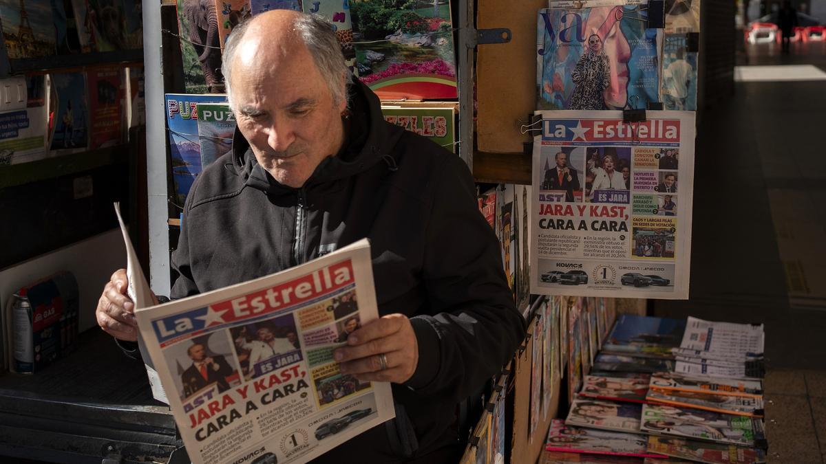 Un hombre lee en un periódico los resultados de las elecciones presidenciales, en una calle de Viña del Mar.