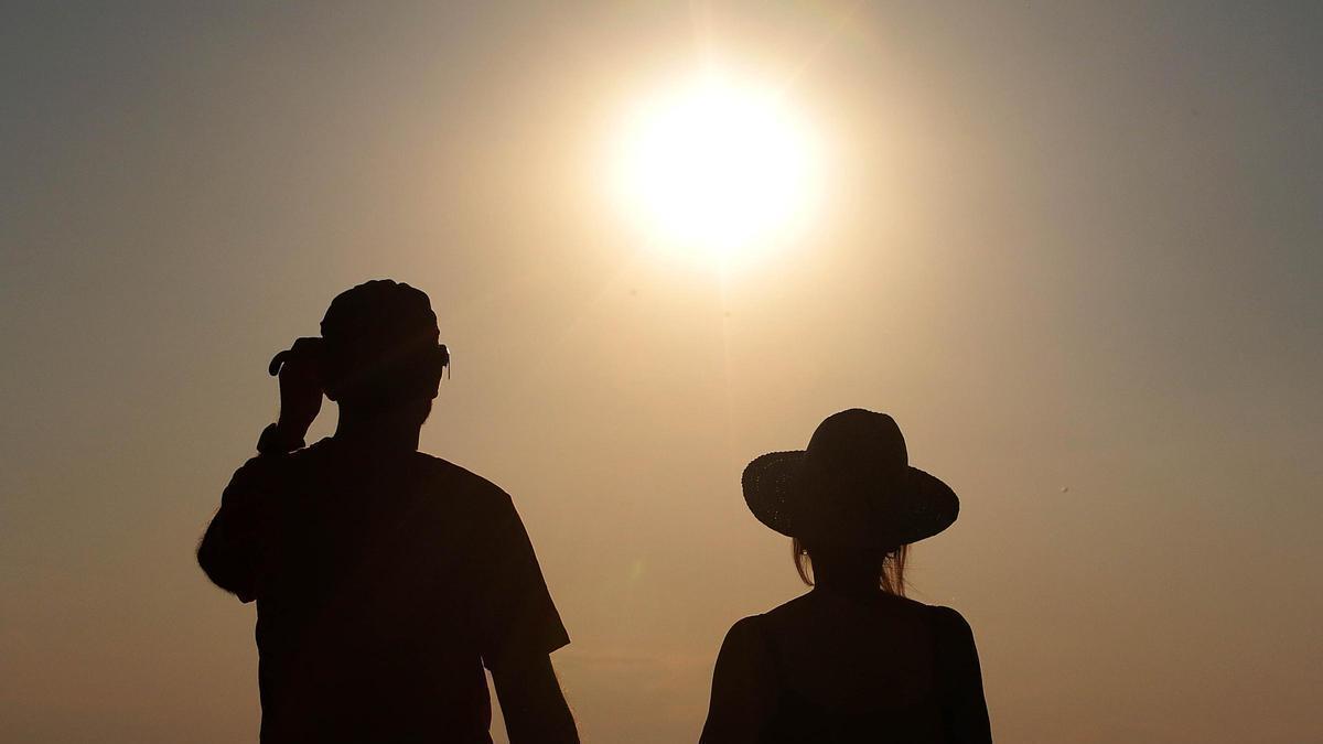 Dos personas observa el eclipse total de sol.