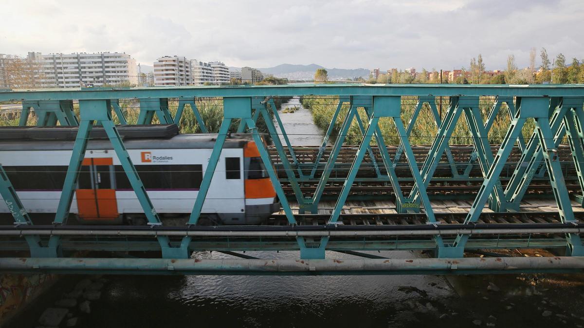 Un tren de Rodalies circulando por el puente del ferrocarril sobre el río Besòs, en Sant Adrià.