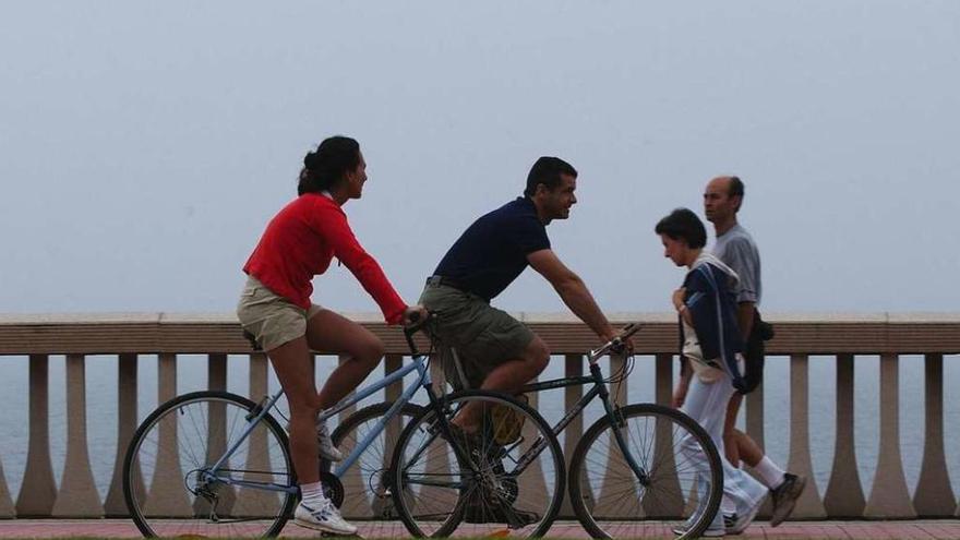 Ciclistas circulando por el carril bici del paseo marítimo.