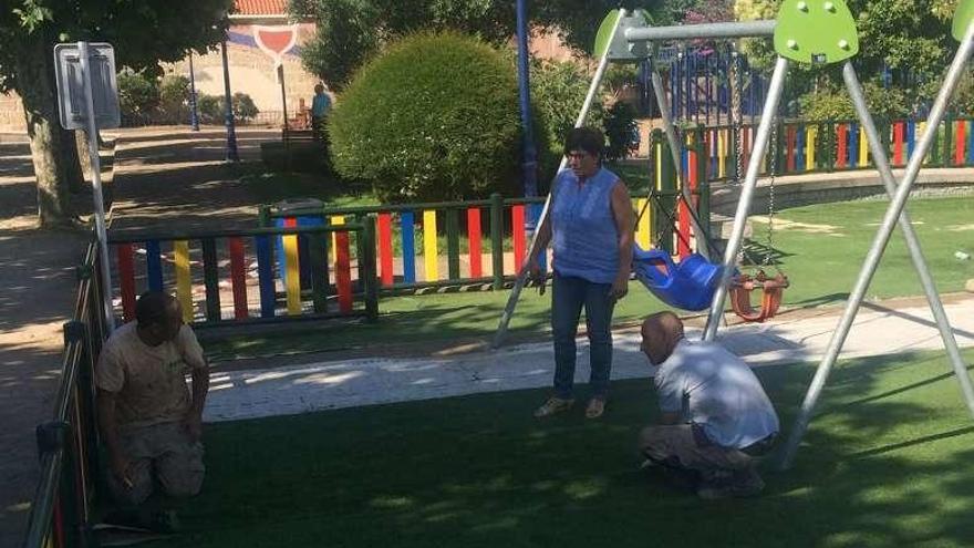 Los operarios cambian el césped del parque infantil de Chapela. // FdV