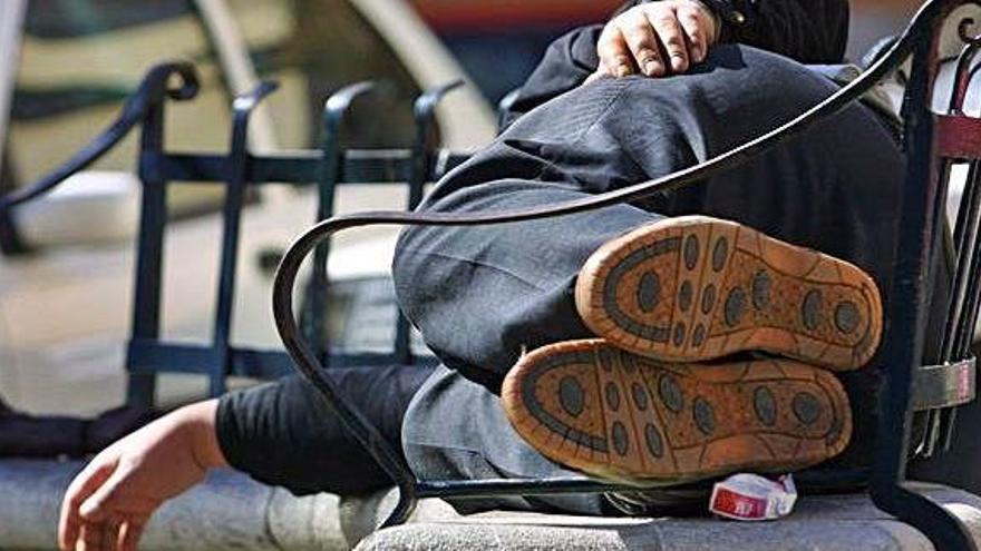 Una persona sin hogar durmiento en una plaza de Palma