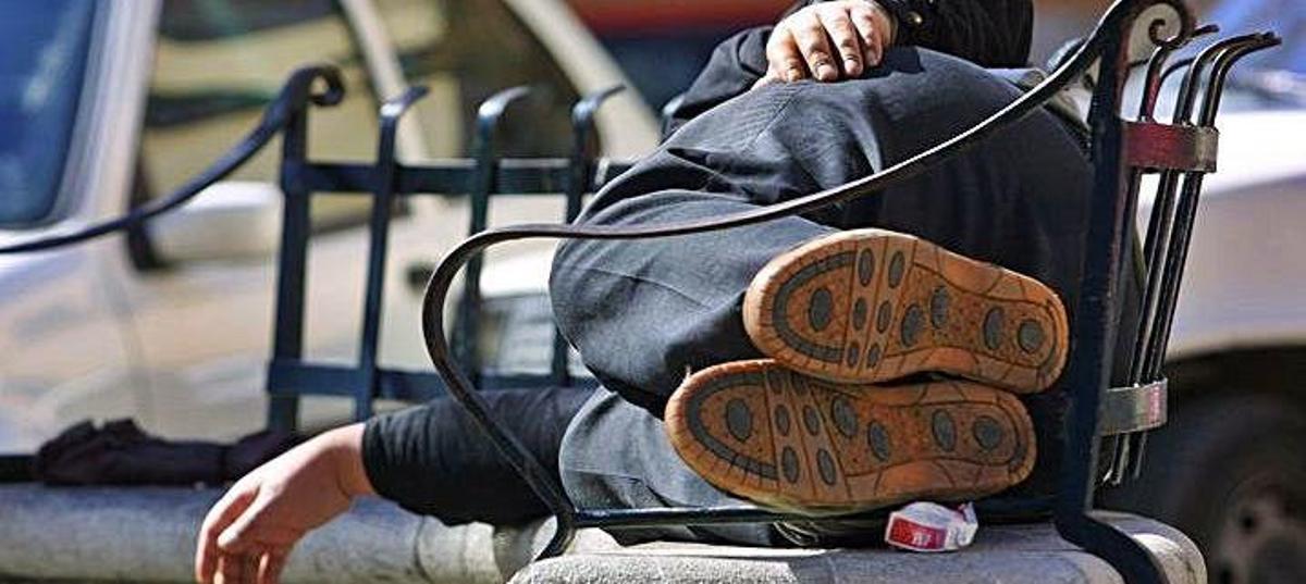 Una persona sin hogar durmiento en una plaza de Palma