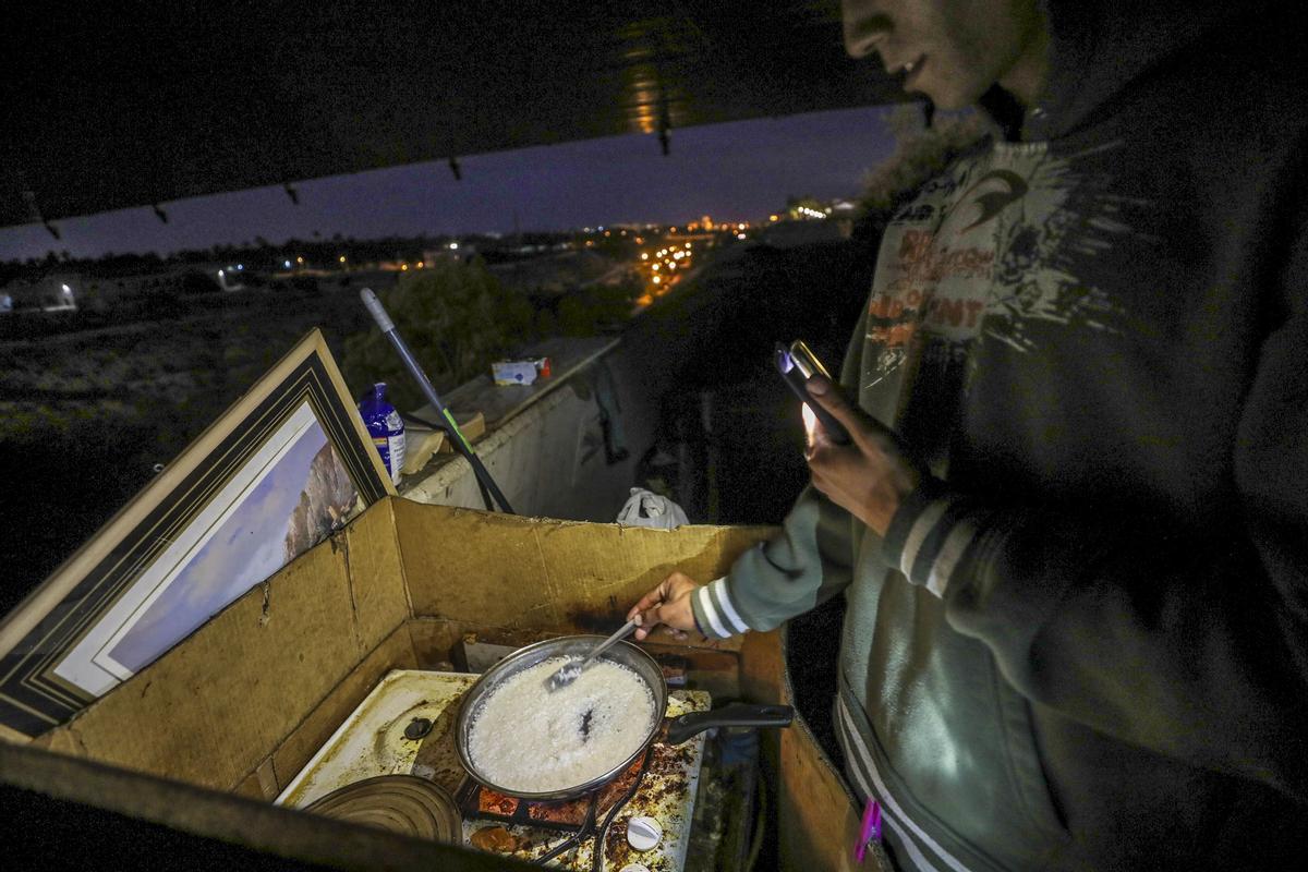 Cocinando bajo el puente al caer la noche