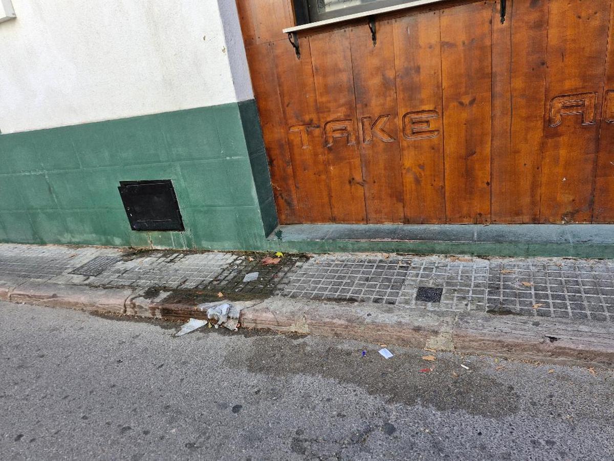 Estrecha acera, con suciedad.