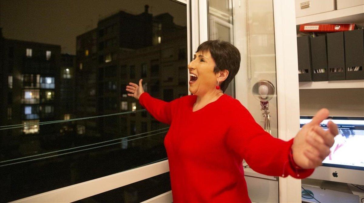 La soprano Begoña Alberdi canta desde su balcón tras los aplausos a los sanitarios, el 16 de marzo, en Barcelona.