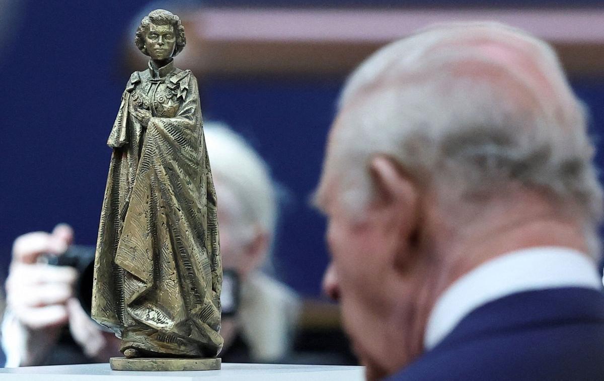 El rey Carlos III contempla una escultura de su madre, Isabel II, durante un acto por el centenario de su nacimiento, este martes en Londres.