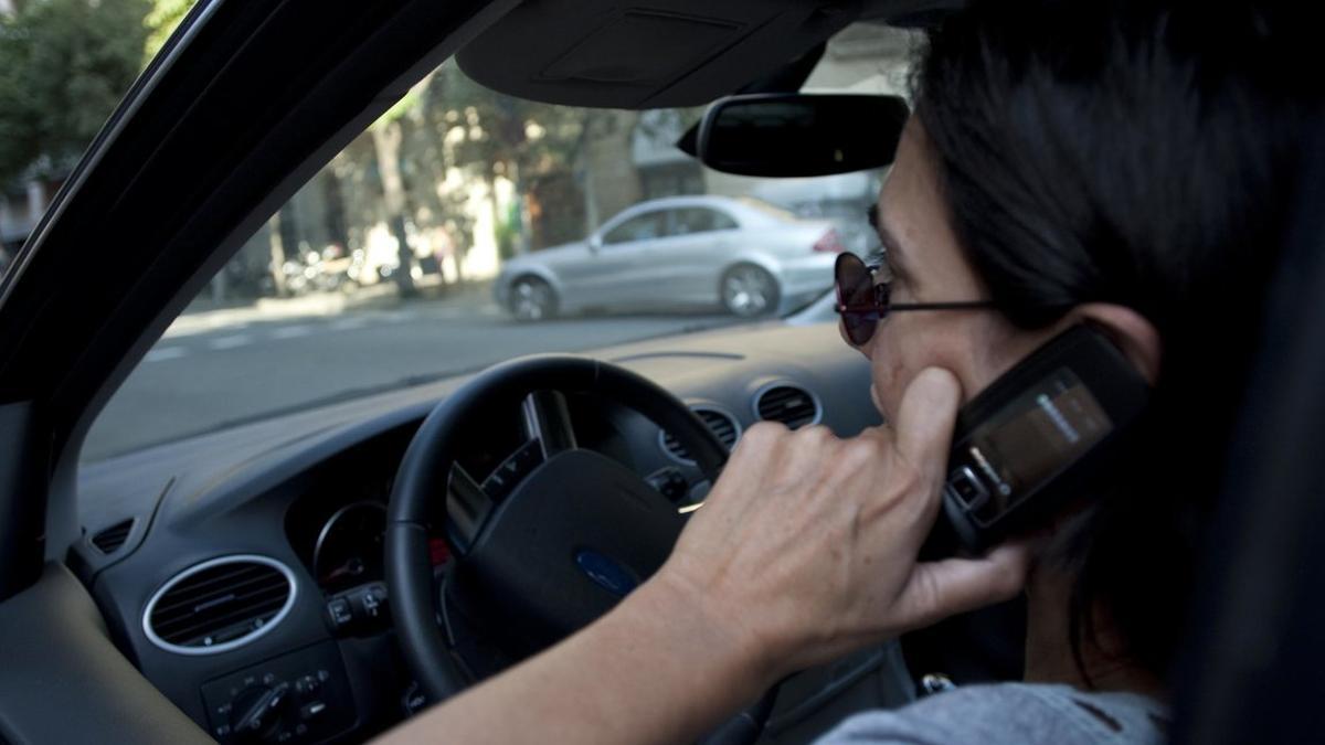 Una mujer habla por teléfono móvil mientras conduce, en una imagen de archivo.