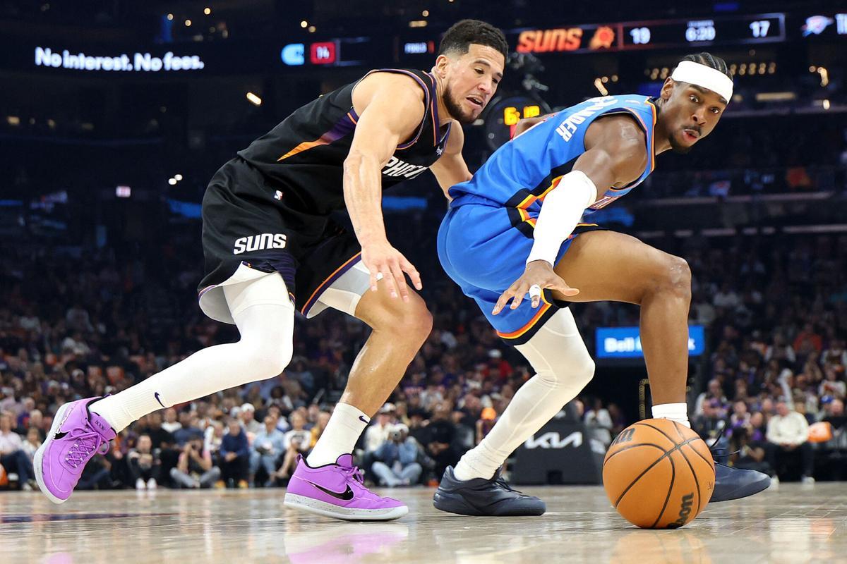 PHOENIX, ARIZONA - APRIL 27: Devin Booker #1 of the Phoenix Suns and Shai Gilgeous-Alexander #2 of the Oklahoma City Thunder reach after a loose ball during the first quarter in Game Four of the First Round of the NBA Western Conference Playoffs at Mortgage Matchup Center on April 27, 2026 in Phoenix, Arizona. NOTE TO USER: User expressly acknowledges and agrees that, by downloading and or using this photograph, User is consenting to the terms and conditions of the Getty Images License Agreement. Christian Petersen/Getty Images/AFP (Photo by Christian Petersen / GETTY IMAGES NORTH AMERICA / Getty Images via AFP). NOTE TO USER: User expressly acknowledges and agrees that, by downloading and or using this photograph, User is consenting to the terms and conditions of the Getty Images License Agreement