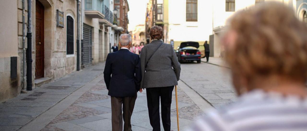 Una pareja de personas mayores caminan por la calle de Ramos Carrión.