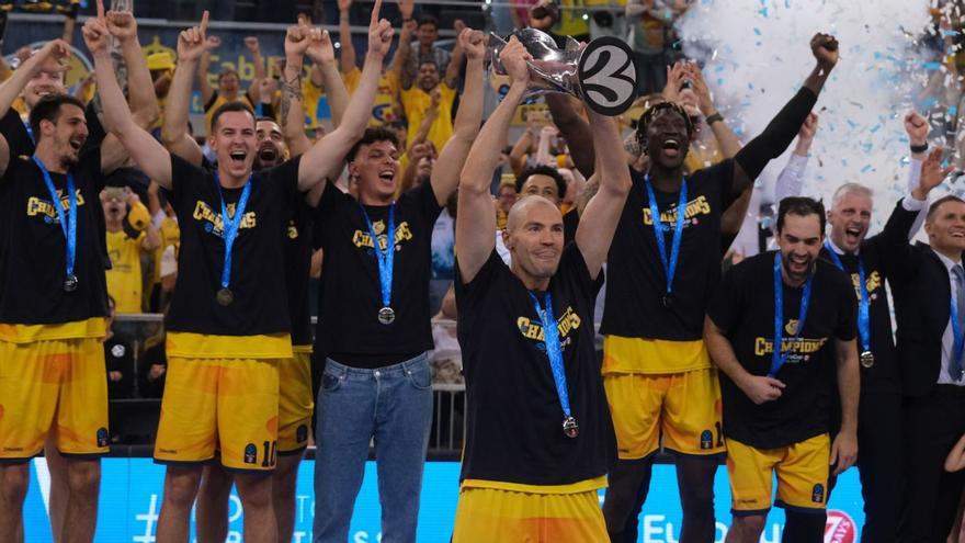 Óliver Stevic –en primer término–, capitán del Granca, levanta la copa de campeón de la Eurocup, con sus compañeros y técnicos detrás, tras ganar la final en el Arena el 3 de mayo de 2023.