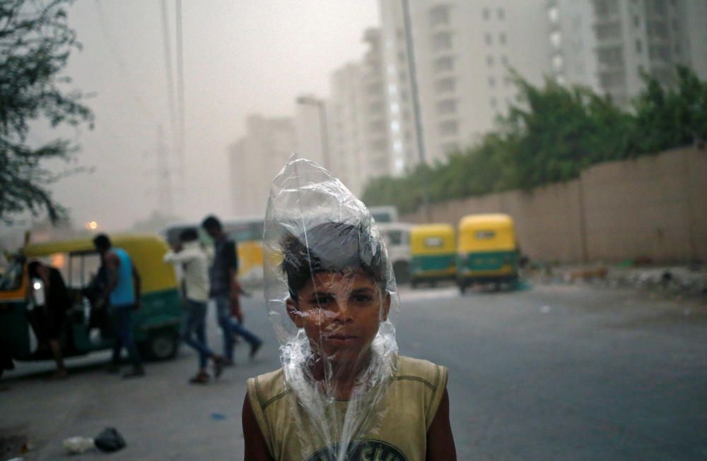 Un chico utiliza una bolsa de plástico para protegerse de una tormenta de arena en Nueva Delhi, India.