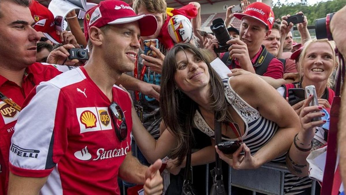 Sebastian Vettel, piloto de Fórmula 1 de Ferrari, posa para una foto con una aficionada en Spa-Francorchamps