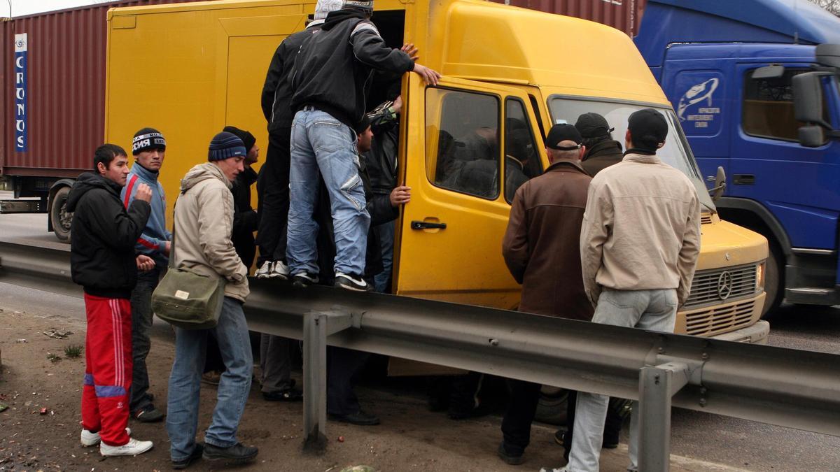 Obreros tayikos de la construcción en la periferia de Moscú se apelotonan en una furgoneta que les llevara al trabajo.