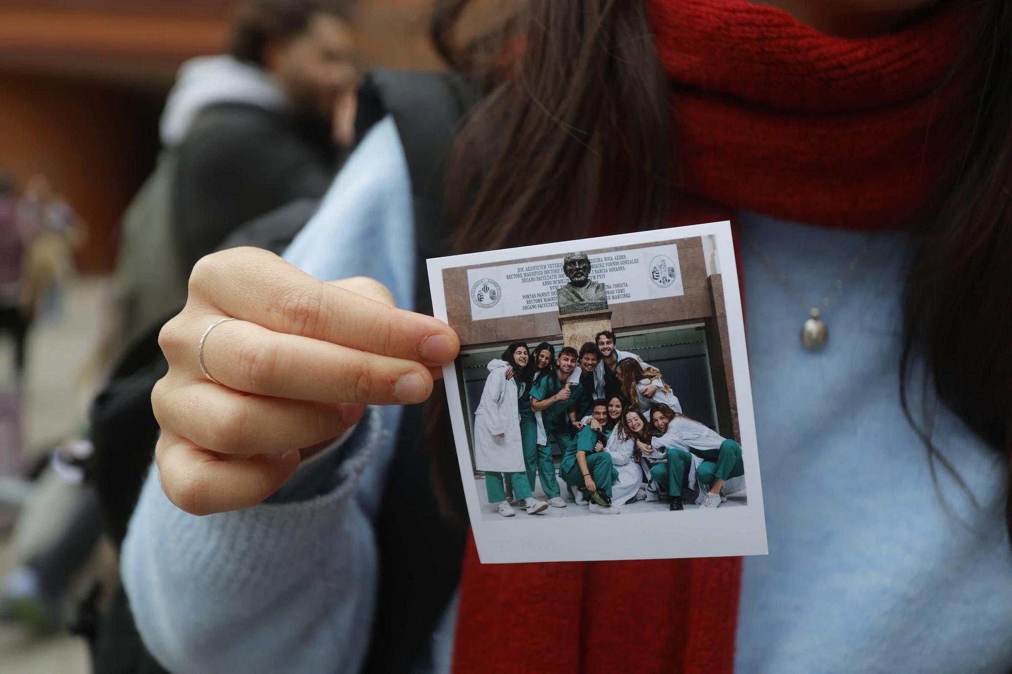 Una joven muestra una foto de su grupo en la facultad.