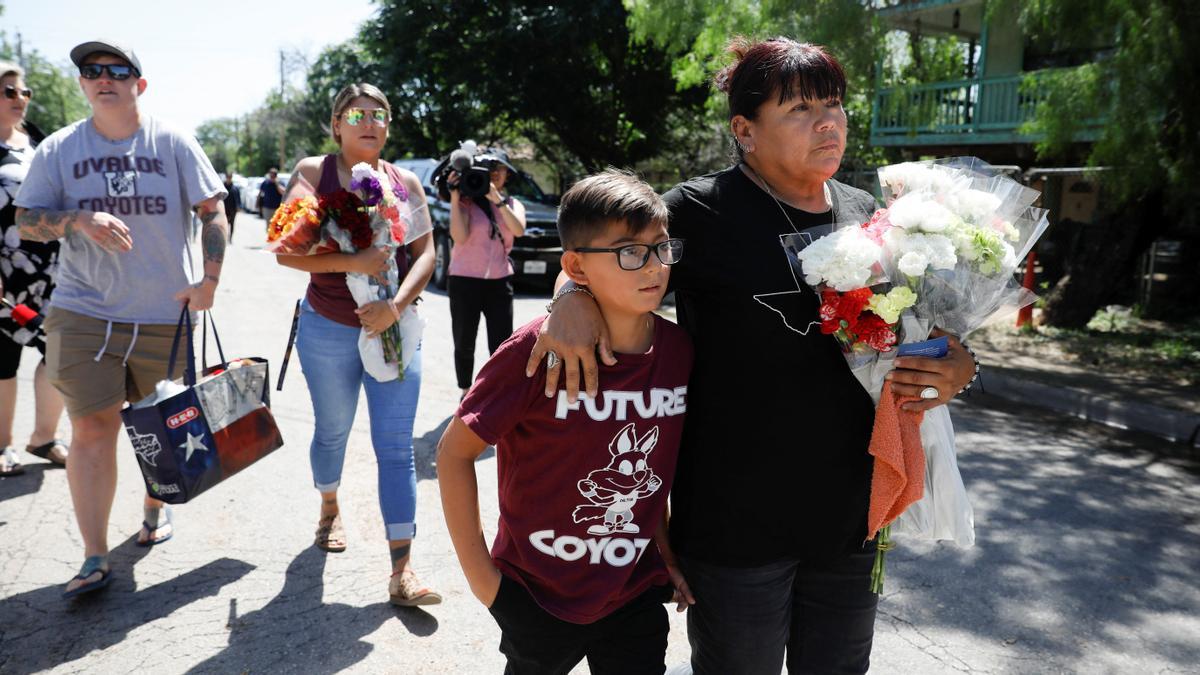 Dora Flores y su nieto llegan a la escuela primaria Robb con flores, el día después de que un hombre armado matara a 19 niños y dos maestros en la escuela de Uvalde, Texas, EE. UU., el 25 de mayo de 2022