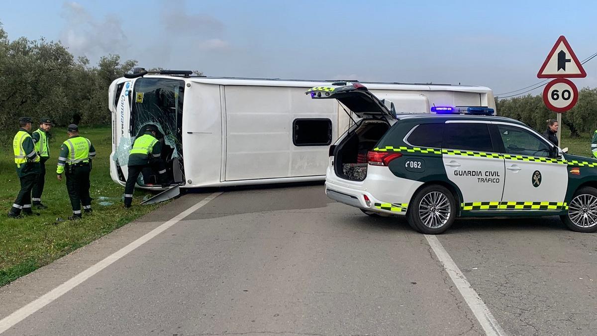 Agentes de la Guardia Civil de Tráfico junto al autobús escolar que ha volcado cuando se dirigía a un colegio de educación especial en Cabra.