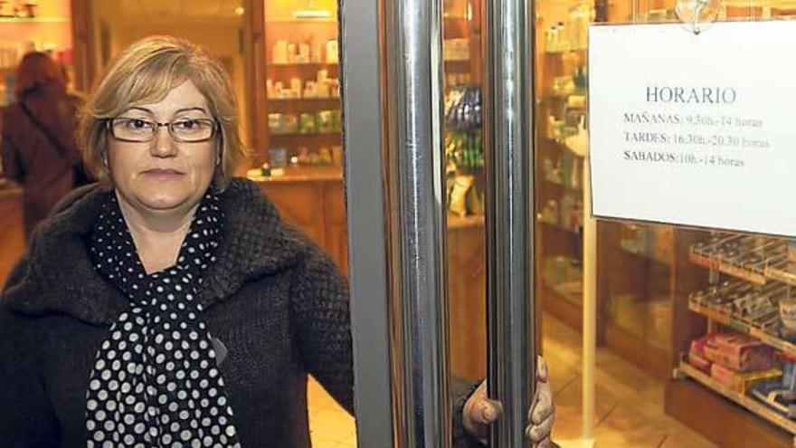 Una clienta sale de una farmacia de Lalín, en donde figura aún el horario actual.  // Bernabé/Javier Lalín