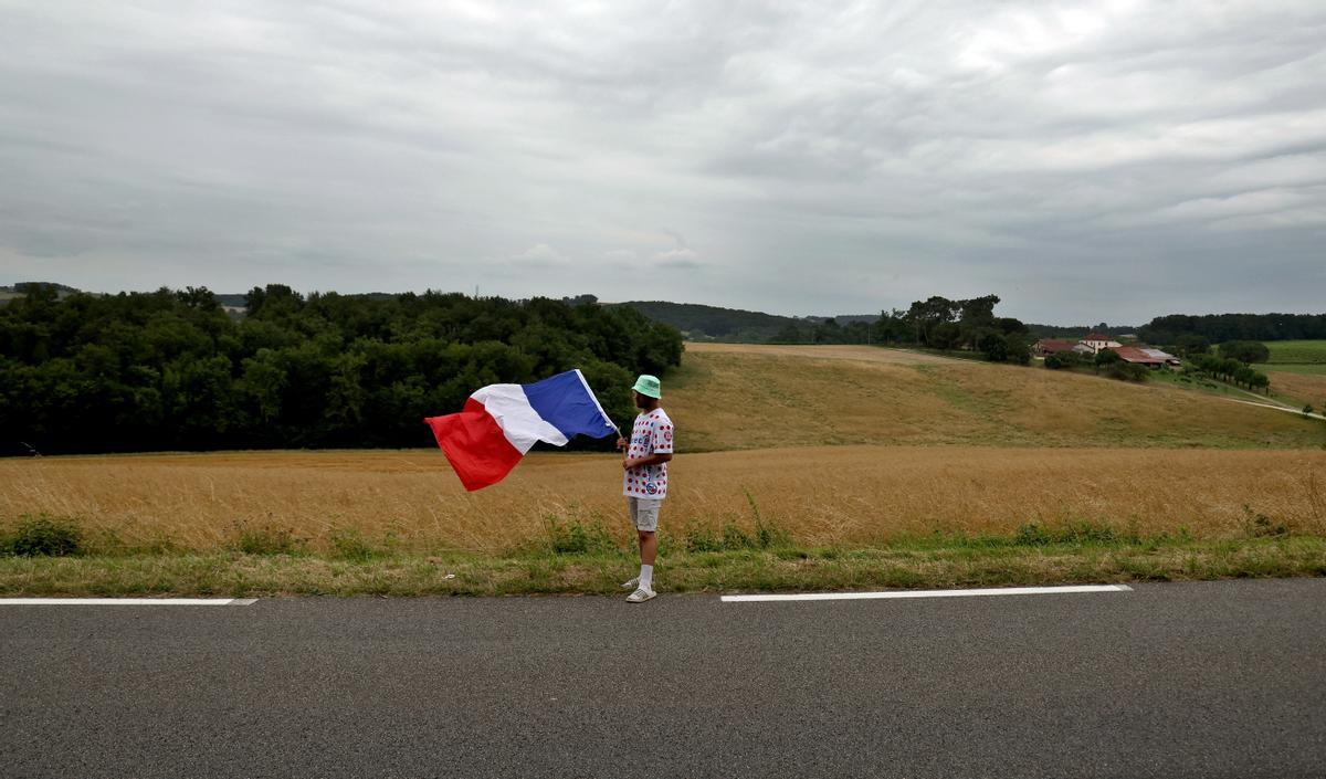 Nogaro (France), 04/07/2023.- A cycling fan holding the French flag waits for the peloton to pass by during the 4th stage of the Tour de France 2023, a 181,8km race from Dax to Nogaro, France, 04 July 2023. (Ciclismo, Francia) EFE/EPA/MARTIN DIVISEK