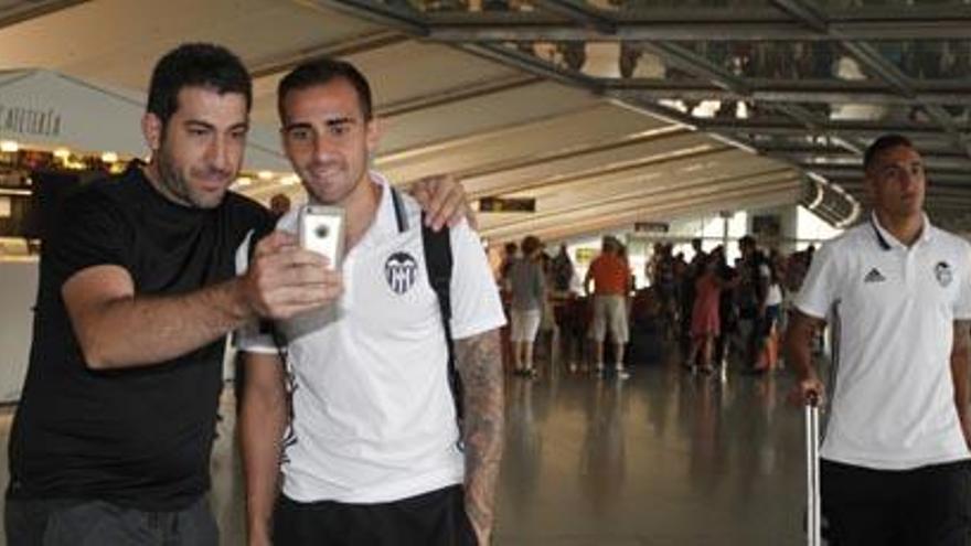 Un sonriente Paco Alcácer atiende a un aficionado, en la llegada del Valencia al aeropuerto de Bilbao.