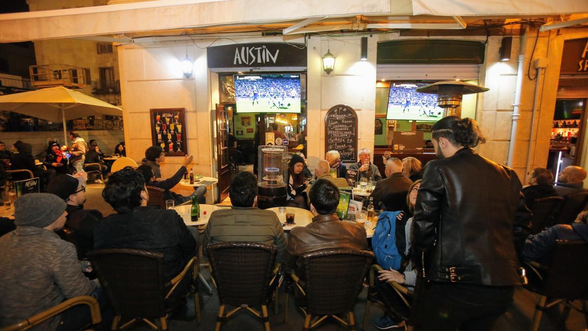 Un grupo de personas, en la terraza de un pub del Barrio.