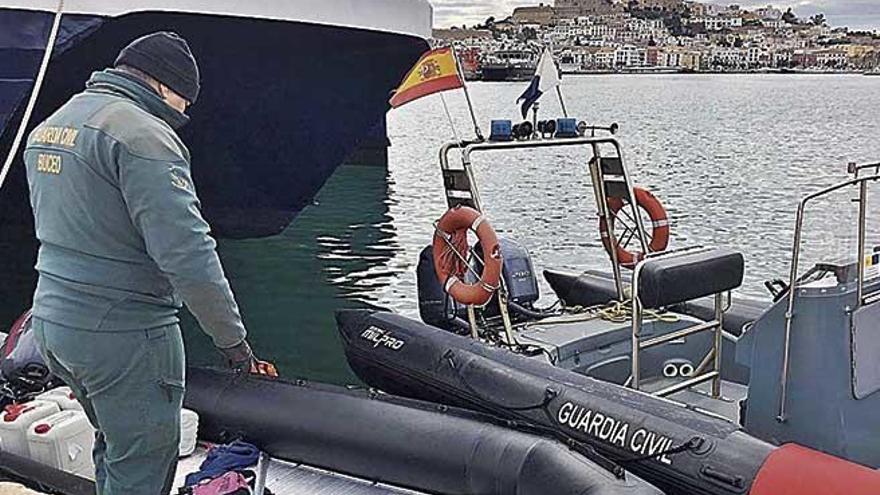 Un agente de la Guardia Civil junto a la lancha en la que navegaban los argelinos que llegaron a Eivissa.