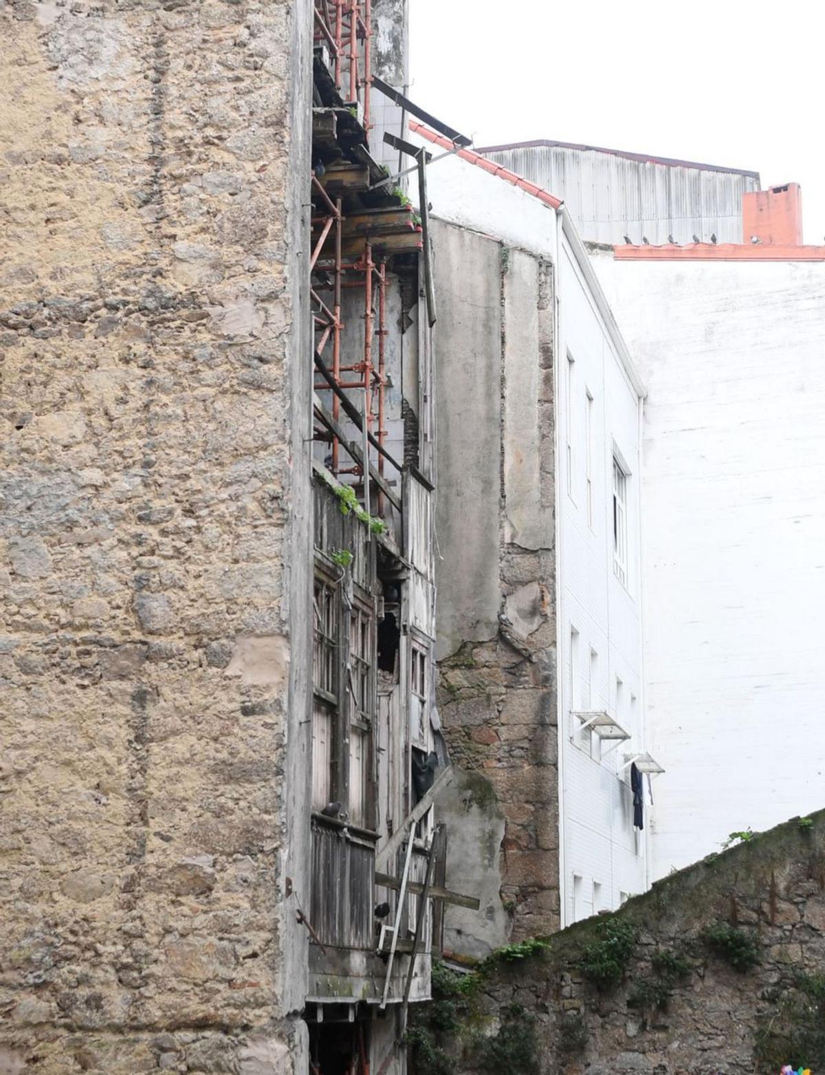 Vecinos de la calle Santa Lucía posan frente al edificio en ruinas para exigir medidas. | // CARLOS PARDELLAS