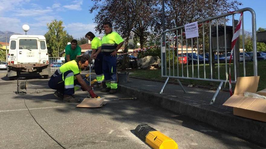 Miembros del plan de empleo del Ayuntamiento de Parres colocando topes en el parking del Hospital de Arriondas, ayer.