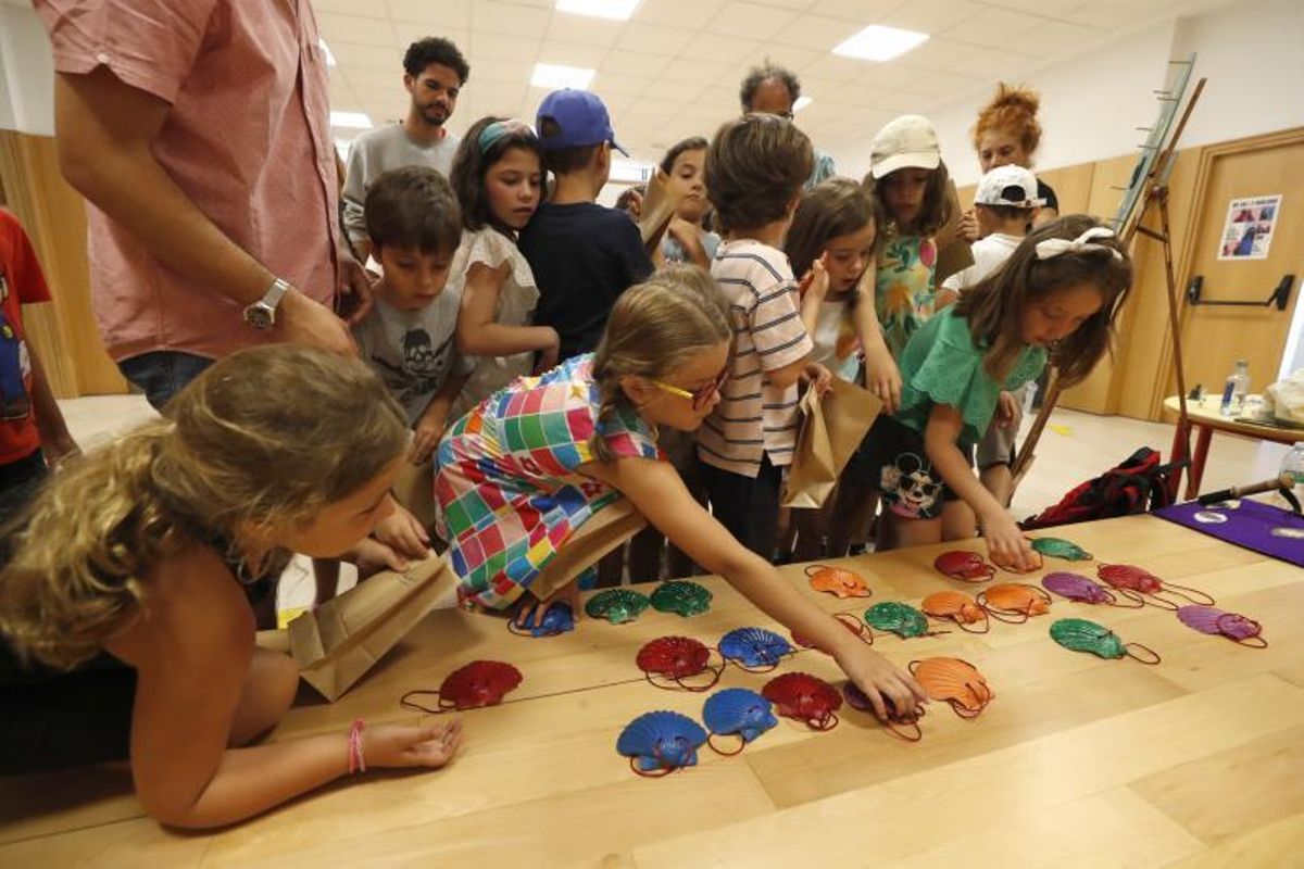 Niños, cogiendo sus conchas de peregrino. | // RICARDO GROBAS