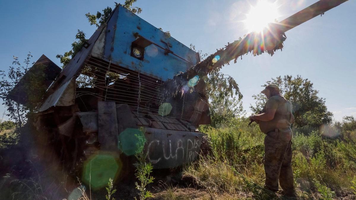 Un soldado ucraniano frente a un tanque ruso abatido por un drone en la región de Donetsk.