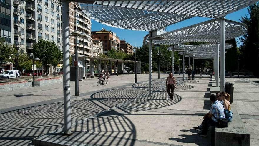 Viandantes pasean y descansan ayer bajo la pérgola de La Marina.