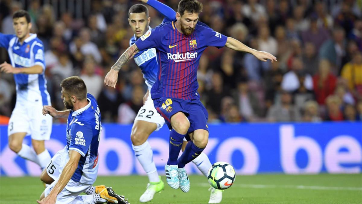 Leo Messi (centro) se escapa de David López (suelo) y Mario Hermoso en el Barça-Espanyol de la Liga 2017/18